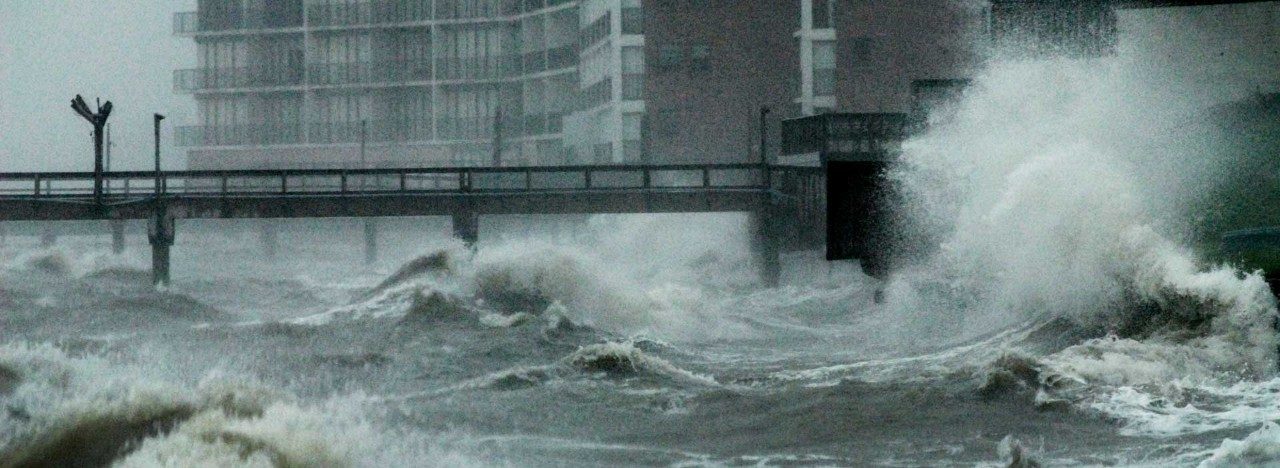 storm-tossed surge of water coming up over a bridge