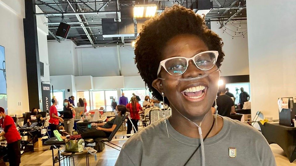 Happy young woman standing in blood collection center smiling with breathing tubes on